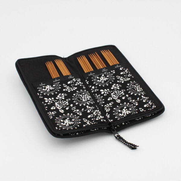 Zippered black and white case, open, containing a set of Chiaogoo double pointed bamboo needles